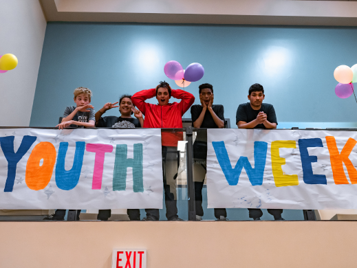 Youth posing with a Youth Week banner