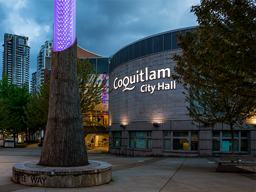A photo of the exterior of Coquitlam City Hall at dusk.