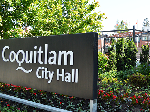 A photo of the City Hall sign with flowers in the background