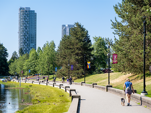 People walking around Lafarge Lake with the city scape in the background