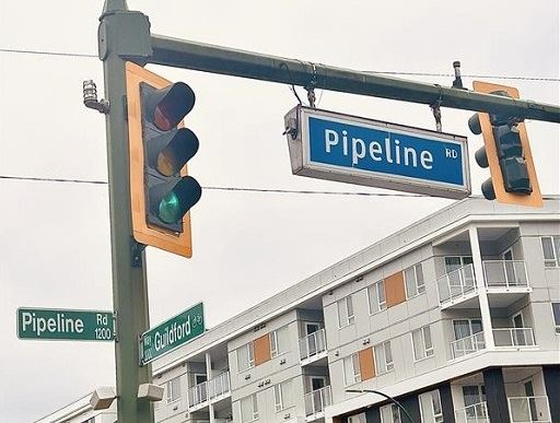 Road sign for Pipeline Road in Coquitlam and green traffic light.