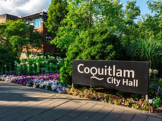 "Coquitlam City Hall" sign in front of floral display
