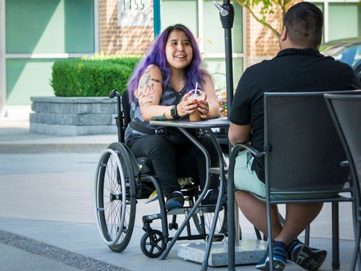 Individual in wheelchair visiting with friend at City Hall.