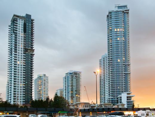 An image of highrises against a dusk sky, with a crane in the background