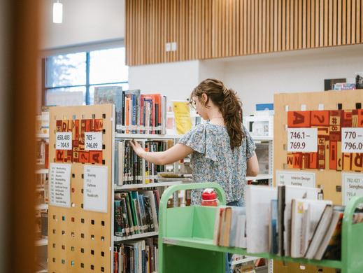 person stocking shelves at a library