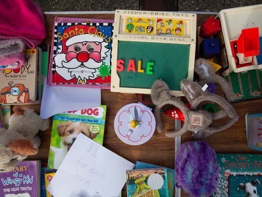 Items for sale at a garage sale, including books and toys