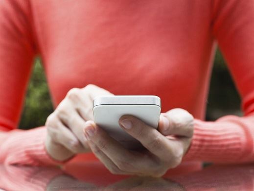 Woman with red shirt uses a cellphone