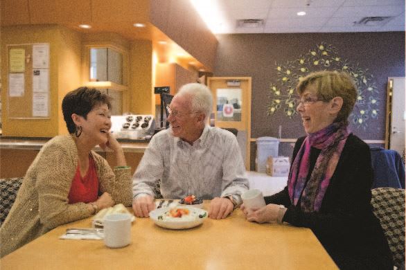 Three adults sit and socialize at Pavilion cafe