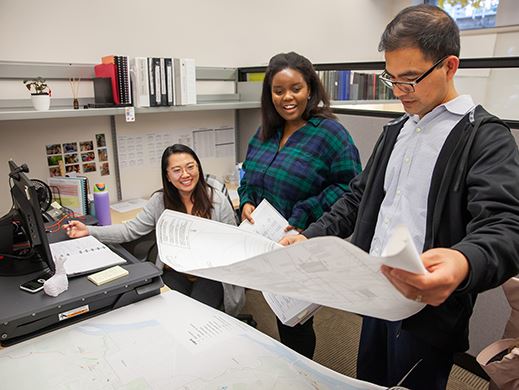 Three Coquitlam staff members look over plans 