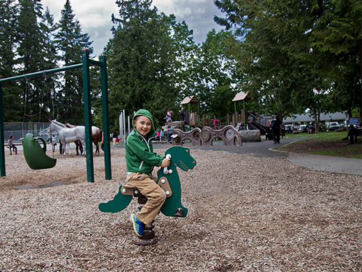 A photo of a child sitting on playground equipment at Blue Mountain Park