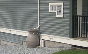 Rain barrel beside a house